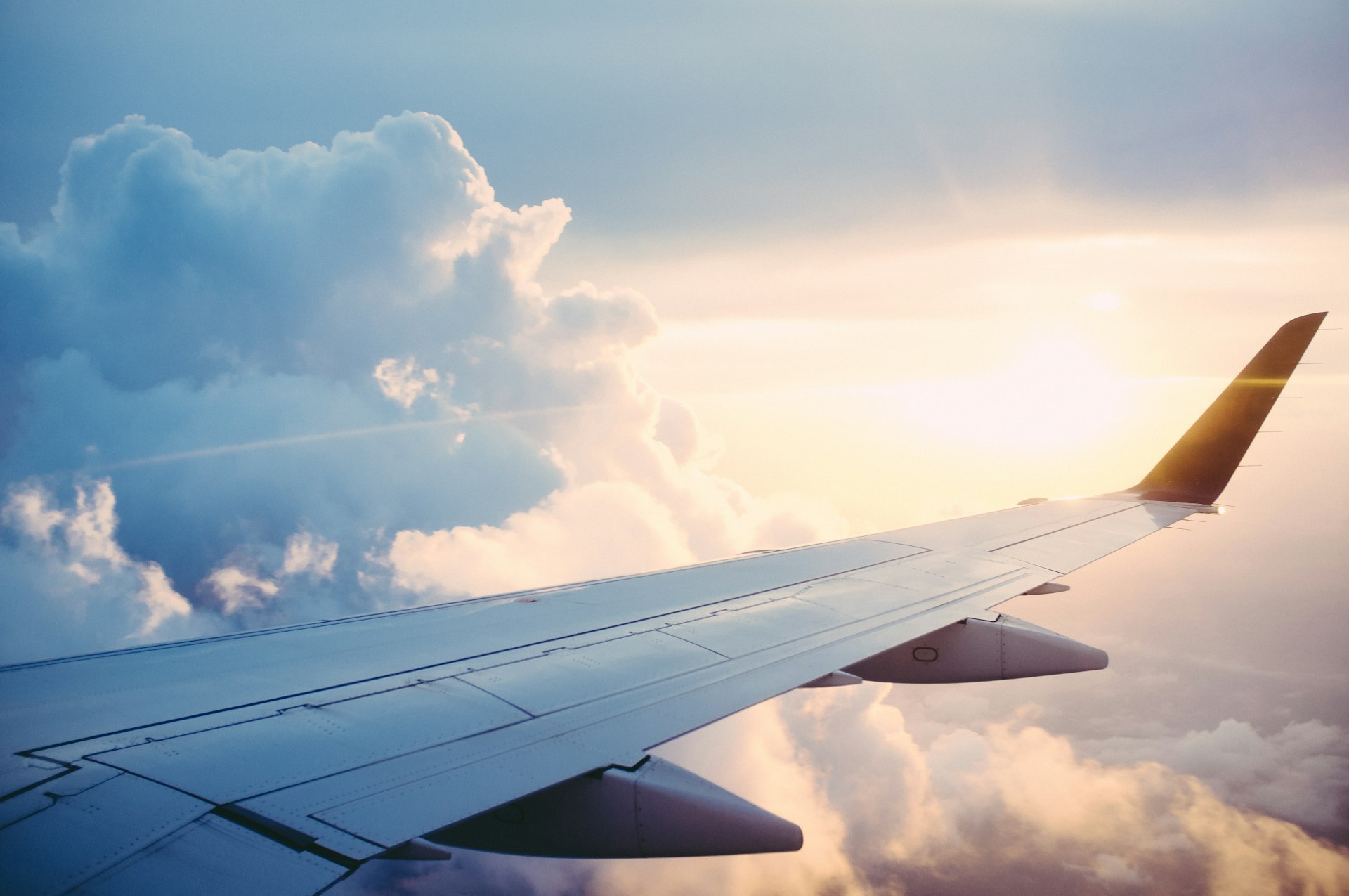 Aircraft wing above clouds at sunset