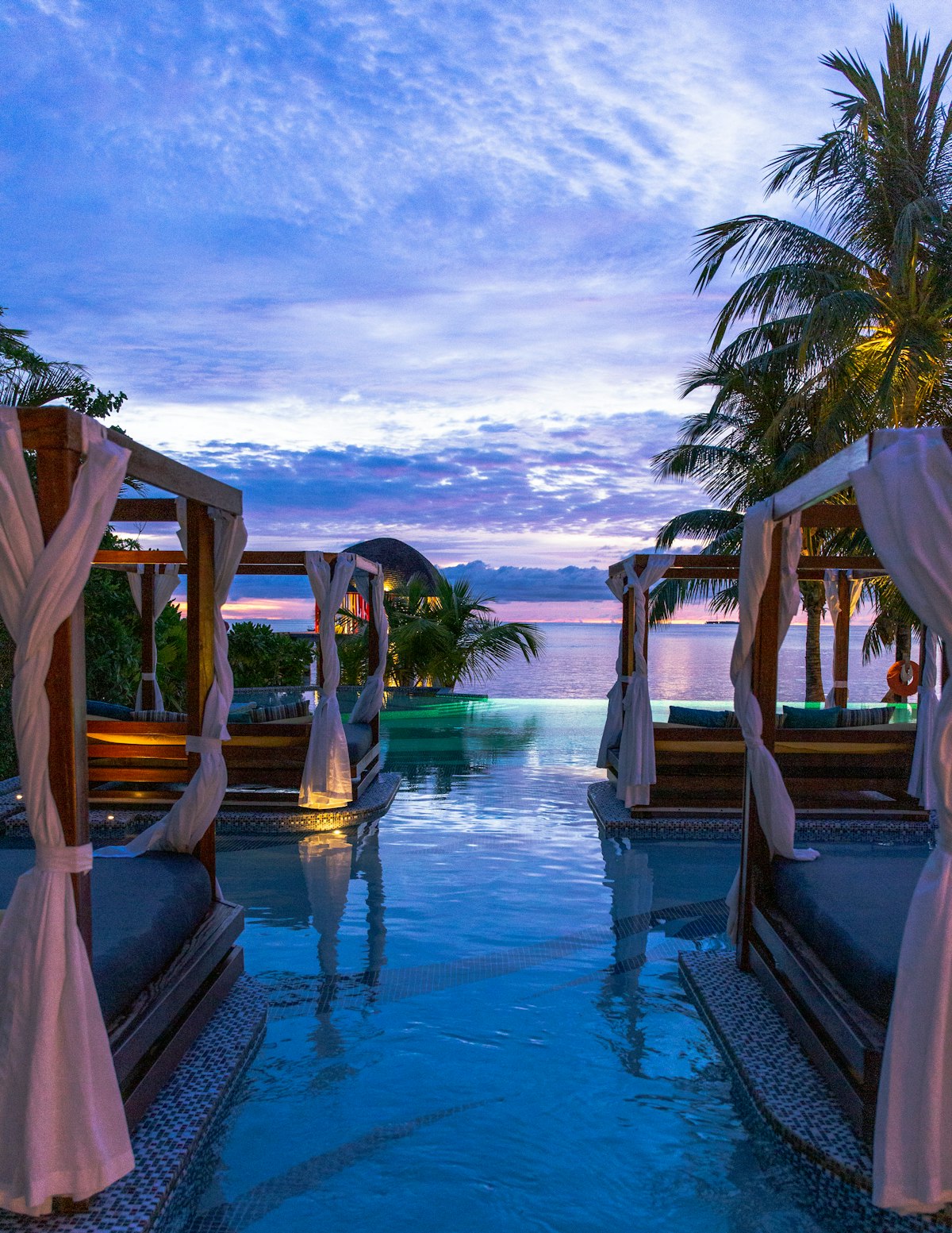 Poolside cabanas at a coastal resort at dusk