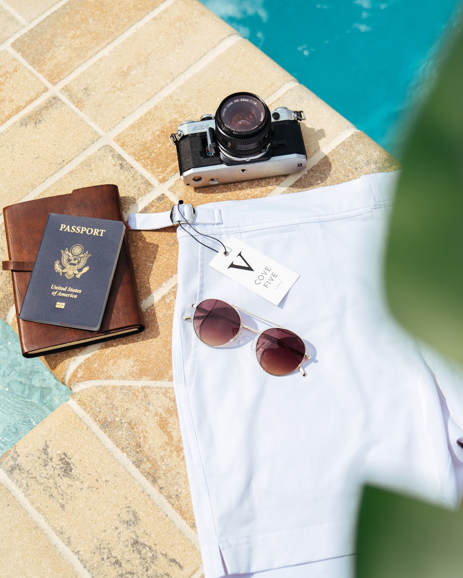 Passport, camera and sunglasses laid by a pool